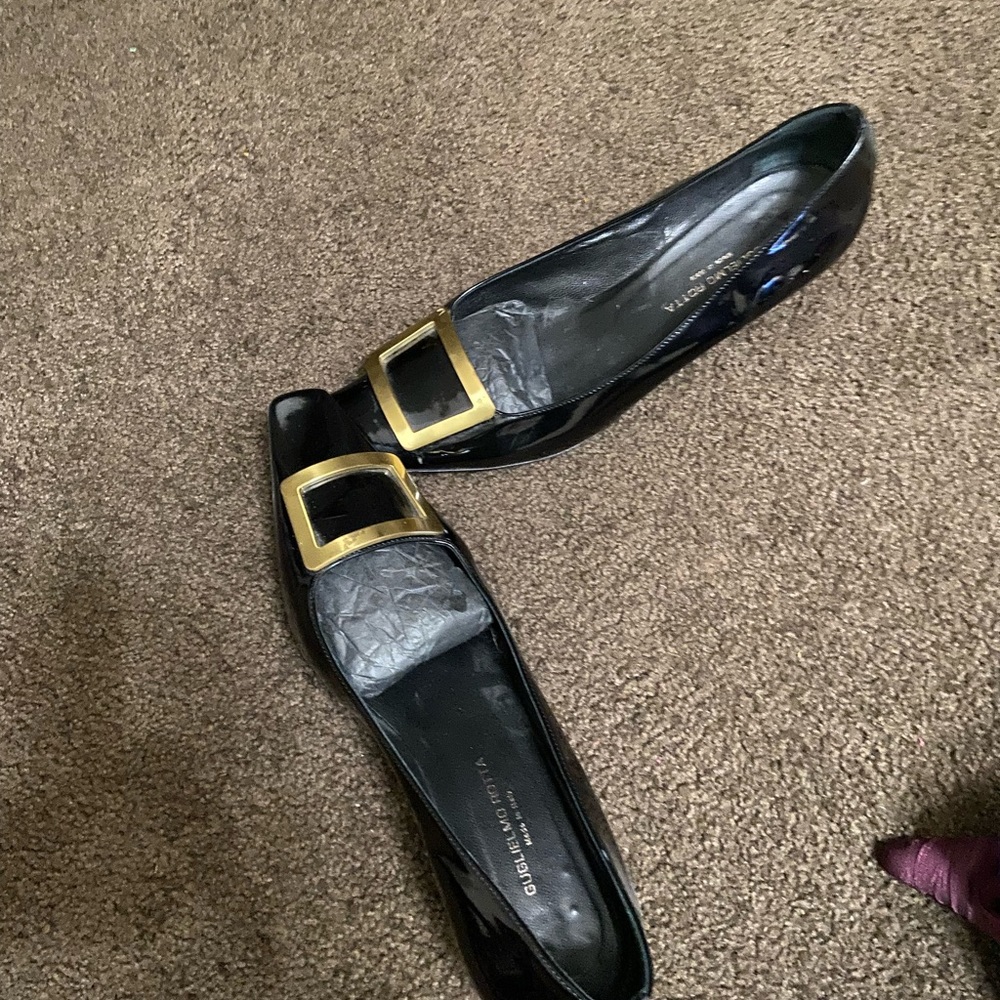 Black glossy material with a bold gold buckle